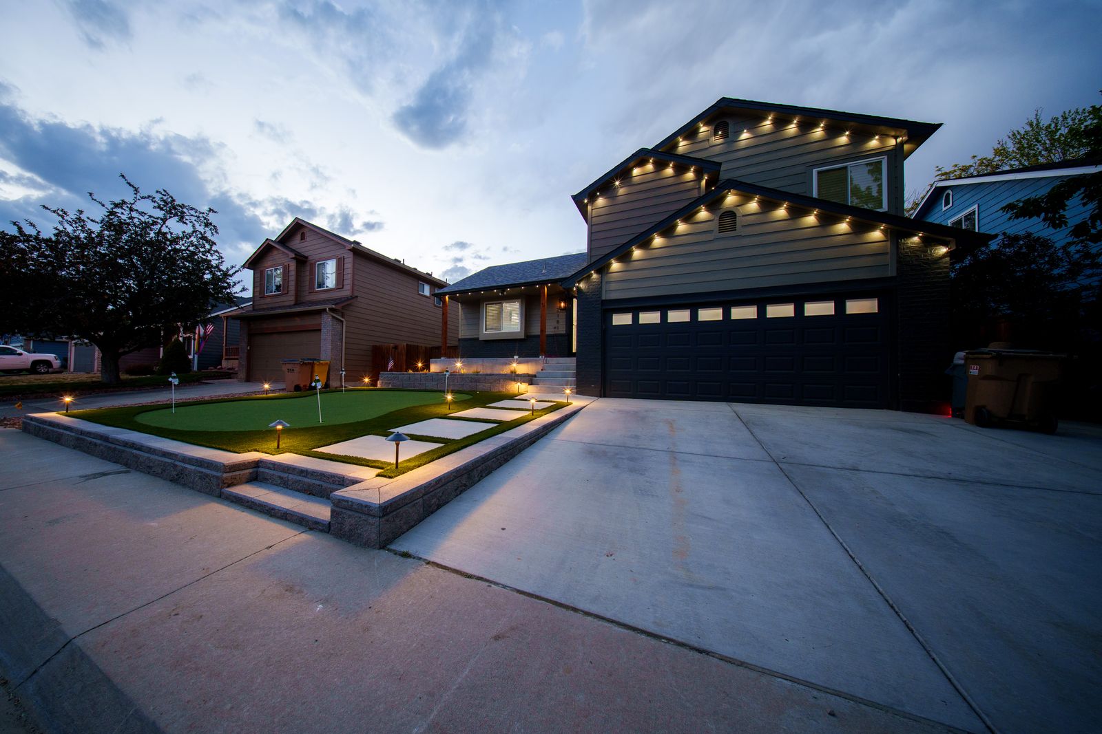 Front-yard landscape with eave lighting at dusk