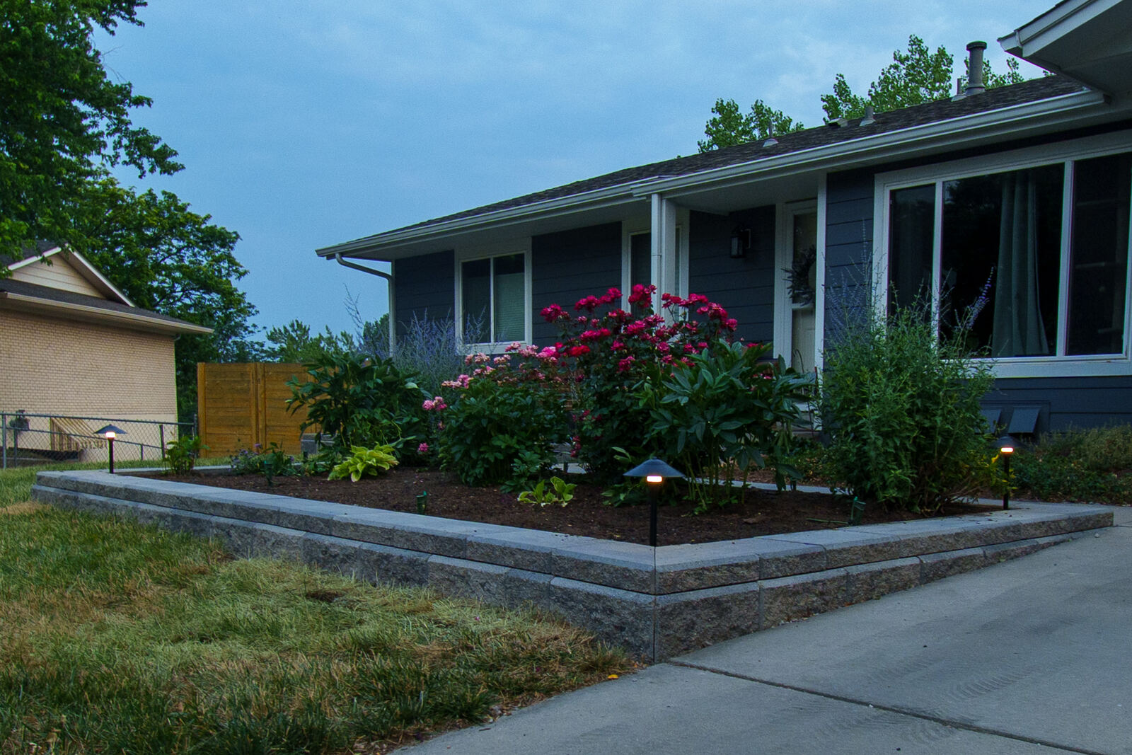 Front planting beds with landscape lighting at dusk