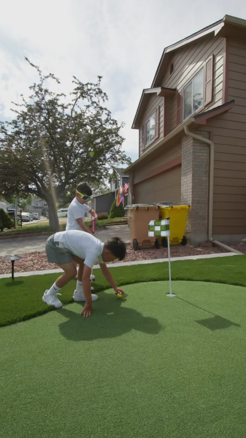 Kids playing on a backyard putting green