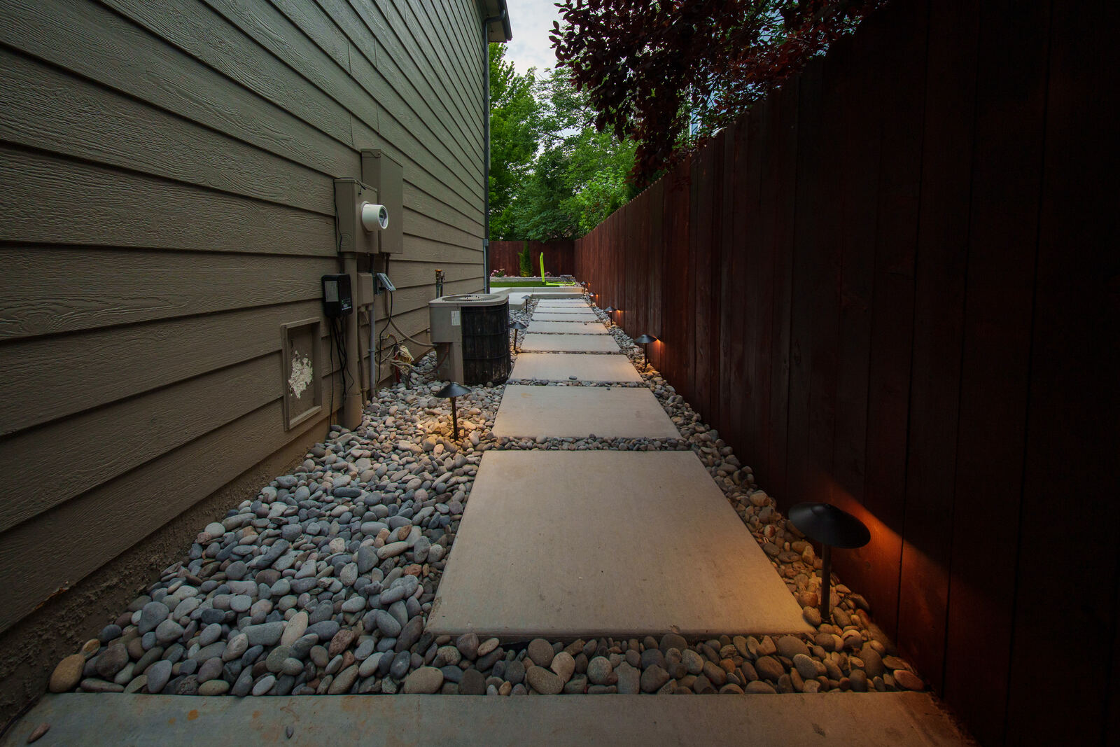 Side-yard paver path with rock and lighting